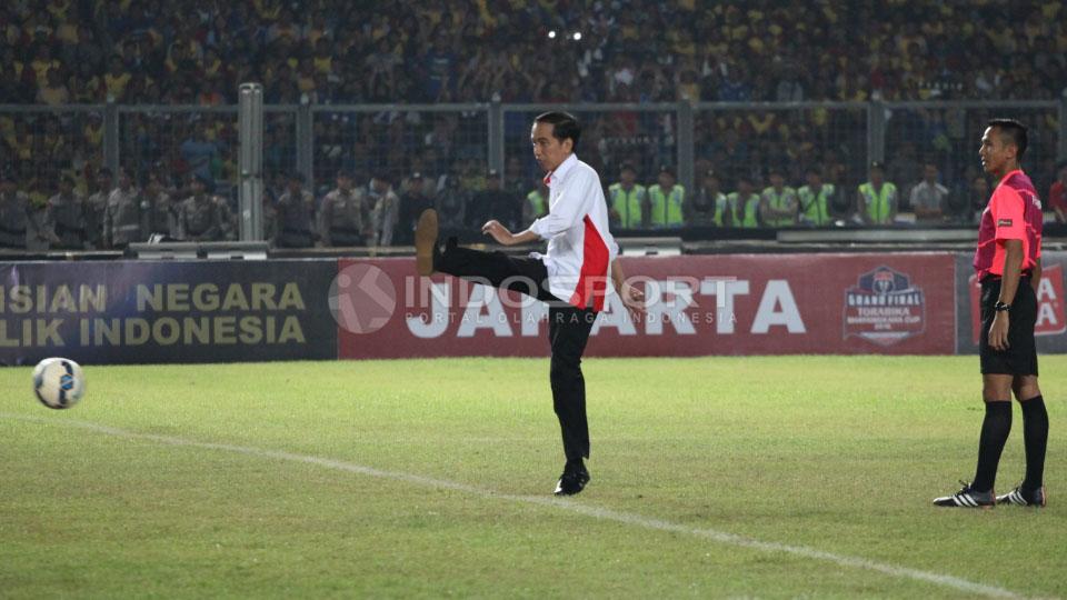 Presiden Joko Widodo melakukan tendangan pembuka pada final Piala Bhayangkara 2016 di Stadion GBK, Minggu (03/04/16). - INDOSPORT